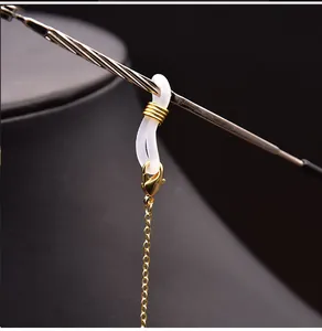 Detail shot of golden eyewear chain featuring a white anti-slip silicone connector loop