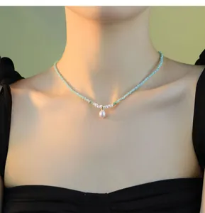 Collier pendentif perle élégant avec perles de verre vert clair sur le cou d'un mannequin