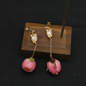 Eleganti orecchini fatti a mano con perle e boccioli di rosa rosa e filo dorato.