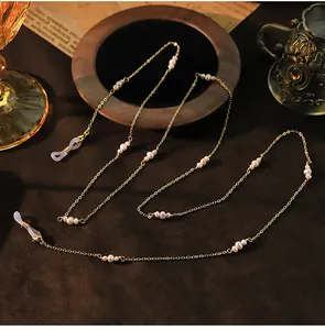 Gedetailleerd zijaanzicht van elegante gouden ketting met natuurlijke parels.