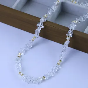 Collier bohème avec cristaux clairs irréguliers et perles sur fond blanc.