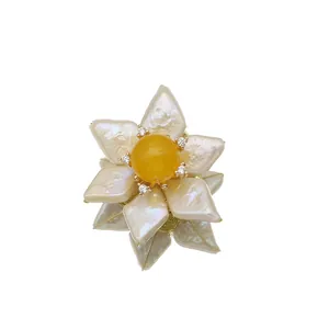 Handmade baroque pearl sunflower brooch with a central yellow jade stone accent