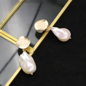 Eleganti orecchini di perle barocche dorate con disco di metallo strutturato e clip.