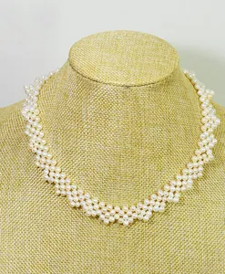 Close-up detail of handmade woven natural freshwater pearl choker necklace on display