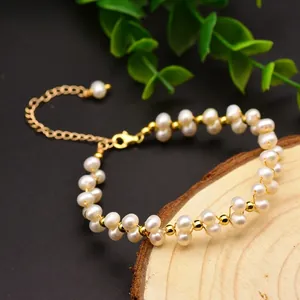 Handgemaakte zoetwaterparel armband met gouden accenten op een natuurlijk houtschijfje