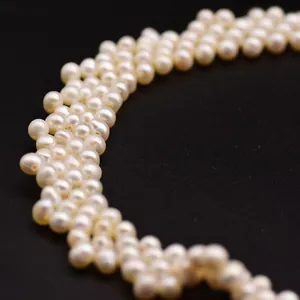 Macro view of woven multi-layer natural freshwater pearl necklace on black background