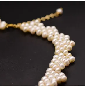 Close-up macro detail of handmade multi-layer woven natural freshwater pearl necklace.