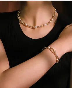 Detailaufnahme eines eleganten Schmucksets mit Perlen und goldenen Kupferperlen an einem Modell