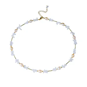 Collier élégant avec perles naturelles et éclats de cristal blanc sur chaîne dorée fine.