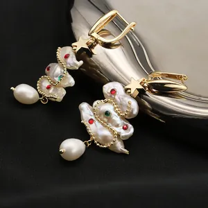 Detailed view of handmade baroque pearl earrings with Christmas tree design and stars