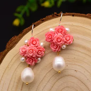 Détail de boucles d'oreilles rose et perle naturelle avec crochets en argent 925