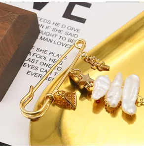 Detailed view of elegant golden safety pin brooch with white baroque freshwater pearls