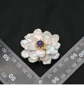 Detailed view of the baroque pearl flower brooch with a size ruler for scale