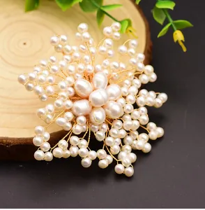 Close-up of elegant handmade freshwater pearl flower brooch with gold wire