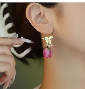 Vue détaillée d'une boucle d'oreille vintage avec rose en résine rose et perles