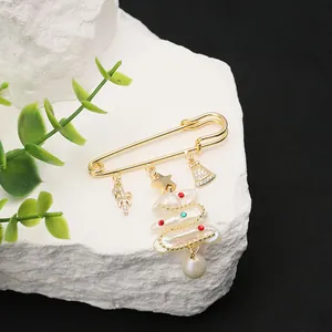 Festive Christmas tree brooch featuring natural pearls and a gold safety pin design.