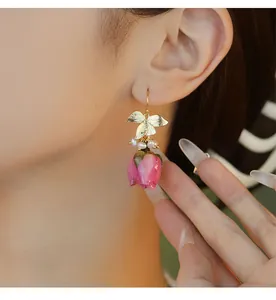 Gros plan détaillé d'une boucle d'oreille rose vintage avec perles et feuilles
