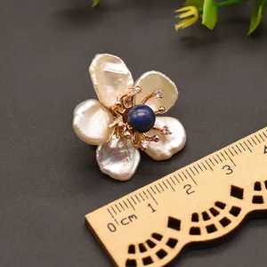 Detailopname van de barokparel bloemspeld met blauw lapis-midden en maataanduiding