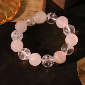 Elegantes Armband aus natürlichen rosa und klaren Kristallperlen auf Vintage-Grund.