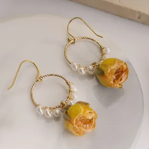 Boucles d'oreilles pendantes à rose en résine jaune avec véritables perles d'eau douce