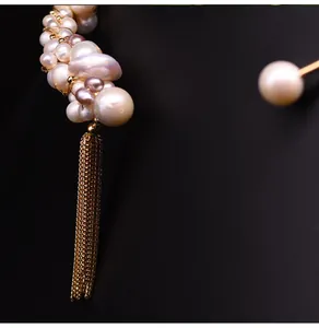 Detailopname van een natuurlijke zoetwaterparelketting met een elegante gouden kwast.