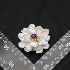 Luxurious handmade baroque pearl flower brooch featuring a vibrant purple gemstone center