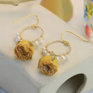 Boucles d'oreilles faites main en résine de rose jaune avec perles et anneaux dorés élégants