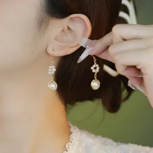 Elegant 18K gold-filled hand-wrapped natural pearl drop earrings shown on model
