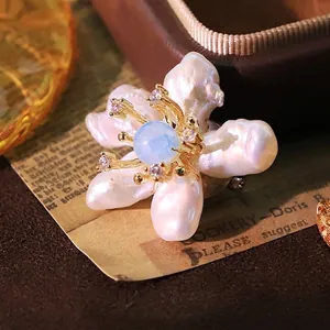 Elegante barokke parel bloem broche met blauwe steen en gouden afwerking