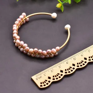 Detail view of a handmade wire-wrapped bracelet with natural pink freshwater pearls.