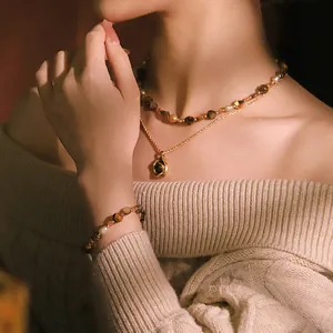 Elegante conjunto de collar y pulsera de ojo de tigre y perlas naturales en mujer