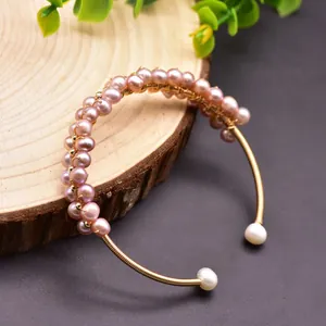 Detailed view of handmade natural freshwater pearl elastic bracelet with gold wire wrapping