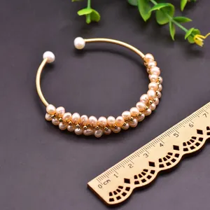 Macro detail of natural freshwater pearl elastic bracelet with handmade gold wire wrapping