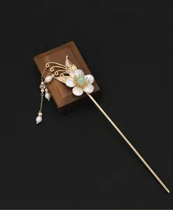 Detailansicht eines eleganten handgefertigten Perlenblumen-Haarstabs mit goldenen Quasten.