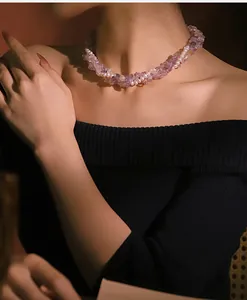 Detail of a three-layer purple crystal and natural pearl necklace on a model's neck.