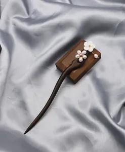 Détail d'un pic à cheveux en bois d'ébène avec perles et fleur en nacre
