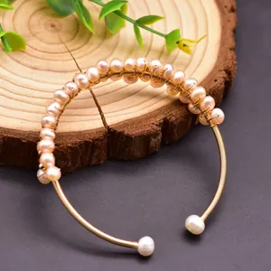Detailed view of an elegant handmade gold wire-wrapped bangle with natural freshwater pearls