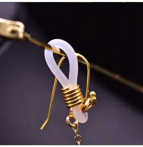 Dettaglio macro del gancio dorato e dell'anello in silicone per catenelle di occhiali