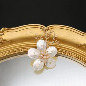 Elegante broche de perlas naturales con pétalos de flores de concha y hojas doradas