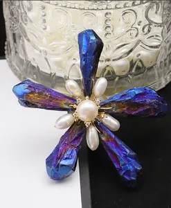 Close-up detail of a handmade baroque star brooch featuring iridescent blue crystals and pearls.