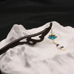 Close-up of a handmade wooden hairpin with pearl and cloisonné lotus tassel detail