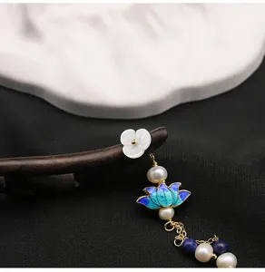 Detailed macro view of a vintage wooden hairpin with Cloisonné lotus and pearl tassels