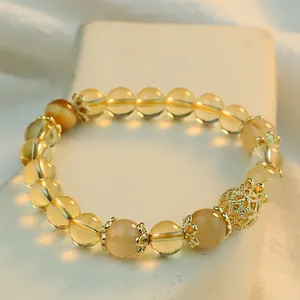 Close-up of yellow crystal bead bracelet with ornate gold spacers and centerpiece