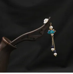 Detailed view of handmade wooden hairpin with blue cloisonne lotus and pearl tassel