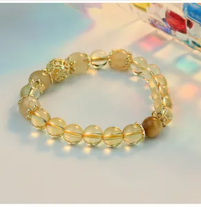 Macro detail shot of a citrine beaded bracelet with golden filigree accents.