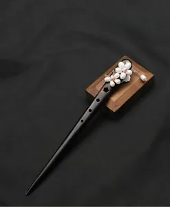 Detail of handmade ebony wood hair stick with natural pearl flower and tassel charm.
