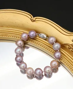 Detailed view of natural purple Edison pearl bracelet with 925 silver clasp on gold mirror.