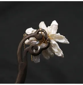 Detailweergave van handgemaakte ebbenhouten haarstok met delicate natuurlijke parelbloem