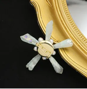 Detail view showing back of baroque crystal and pearl brooch with gold-tone pin.