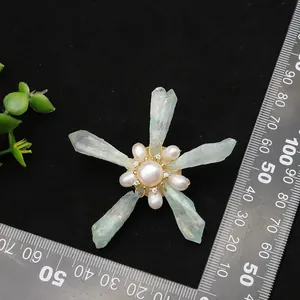 Handmade five-pointed star brooch featuring freshwater pearls and raw green crystals